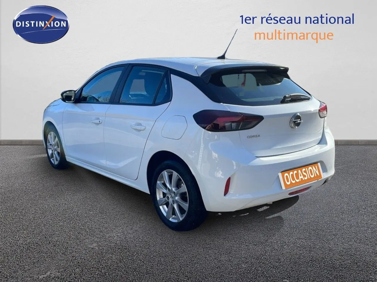 Opel Corsa blanc glacier vue 3/4 arrière côté gauche, avec jantes alliage et feux arrière foncés.