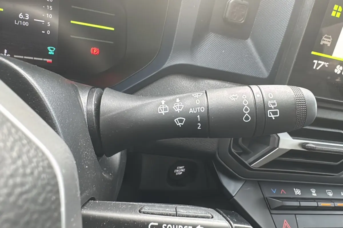 Gros plan sur la commande des essuie-glaces du tableau de bord du Dacia Duster 2025, intérieur noir.