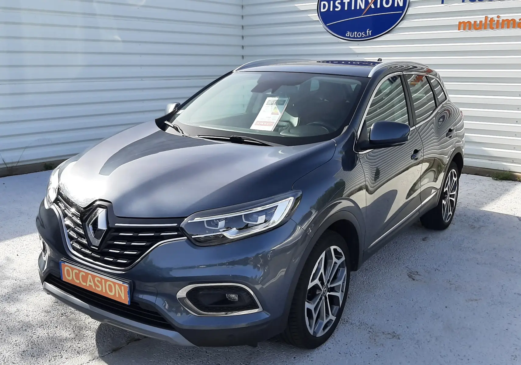 Renault Kadjar gris titanium en 3/4 avant droit, SUV compact avec jantes alliage et calandre noire distinctive.