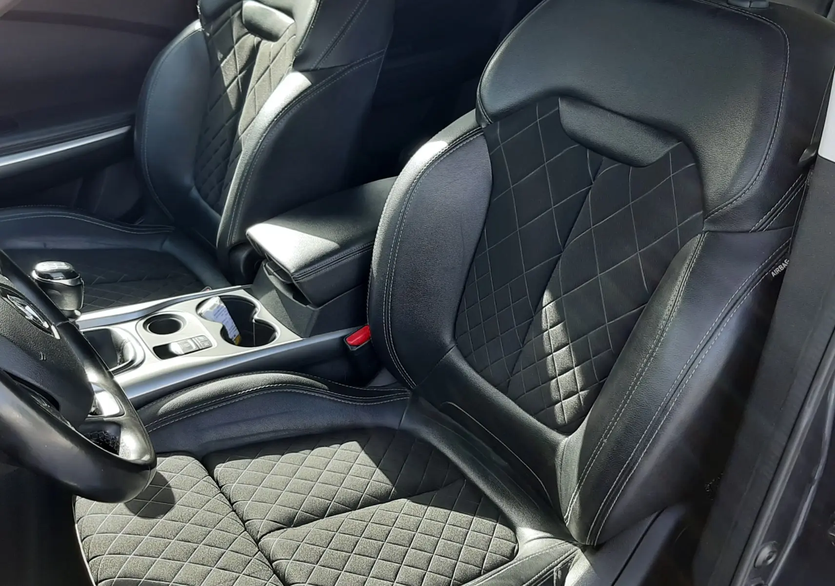 Vue intérieure rapprochée des sièges avant en cuir noir matelassé du Renault Kadjar 1.5 Blue dCi 115ch Intens 2021.