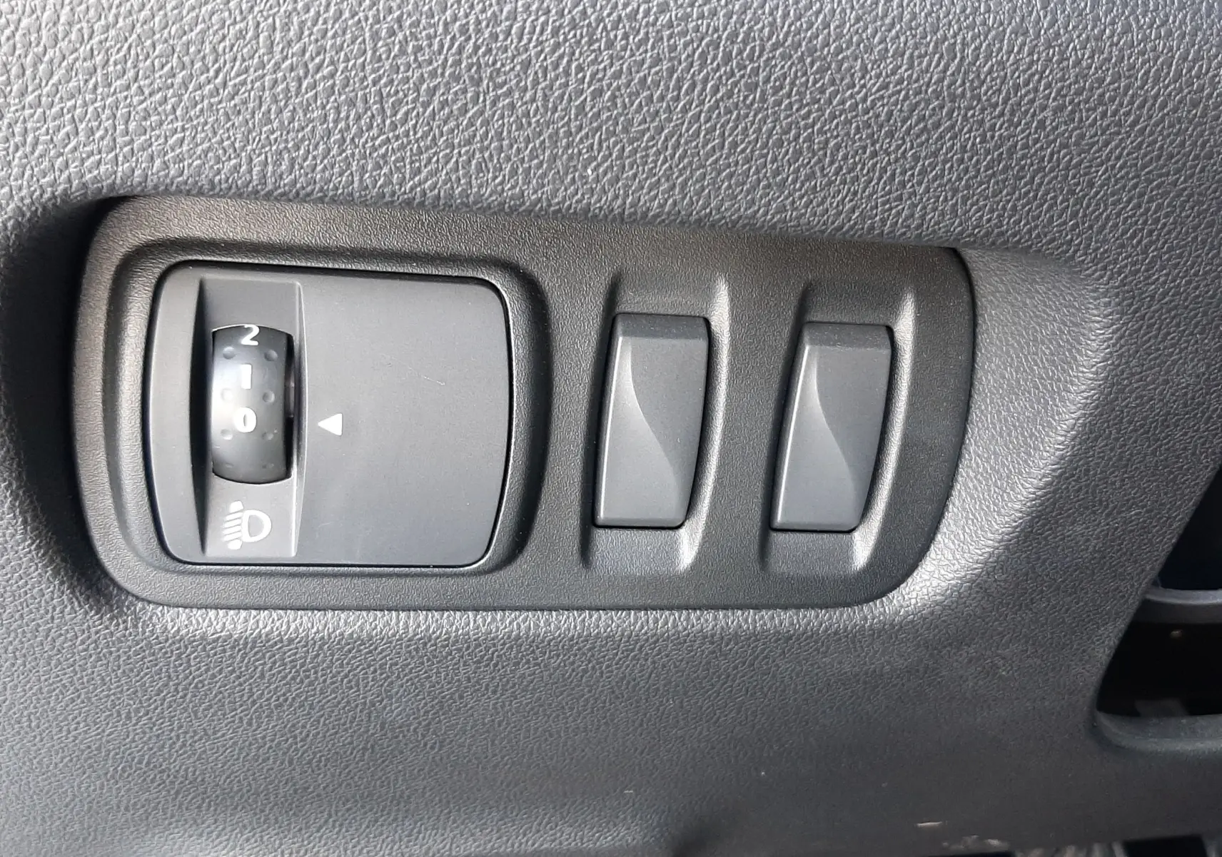 Gros plan sur les commandes d’éclairage et réglages situés à gauche du tableau de bord du Renault Kadjar gris titanium.