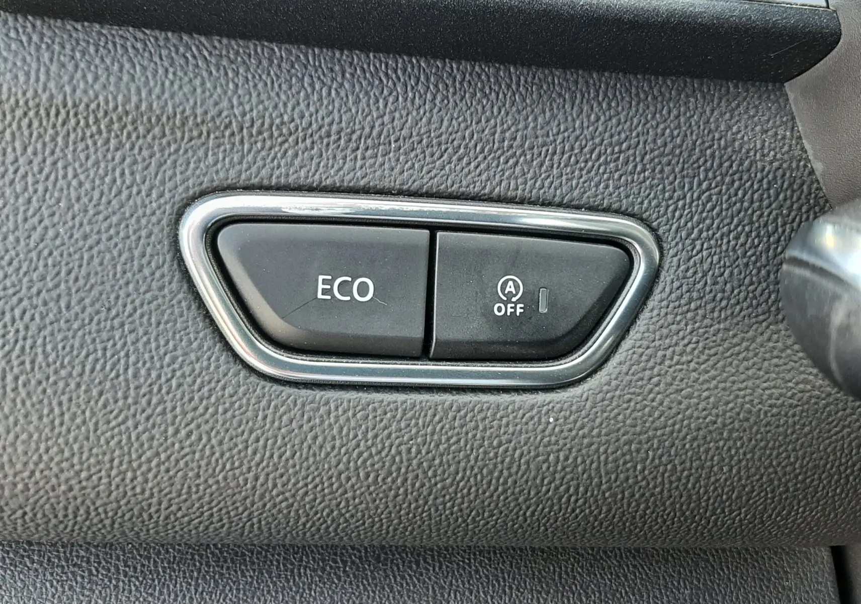 Gros plan sur les boutons ECO et désactivation du start-stop sur le tableau de bord noir du Renault Kadjar 2021.