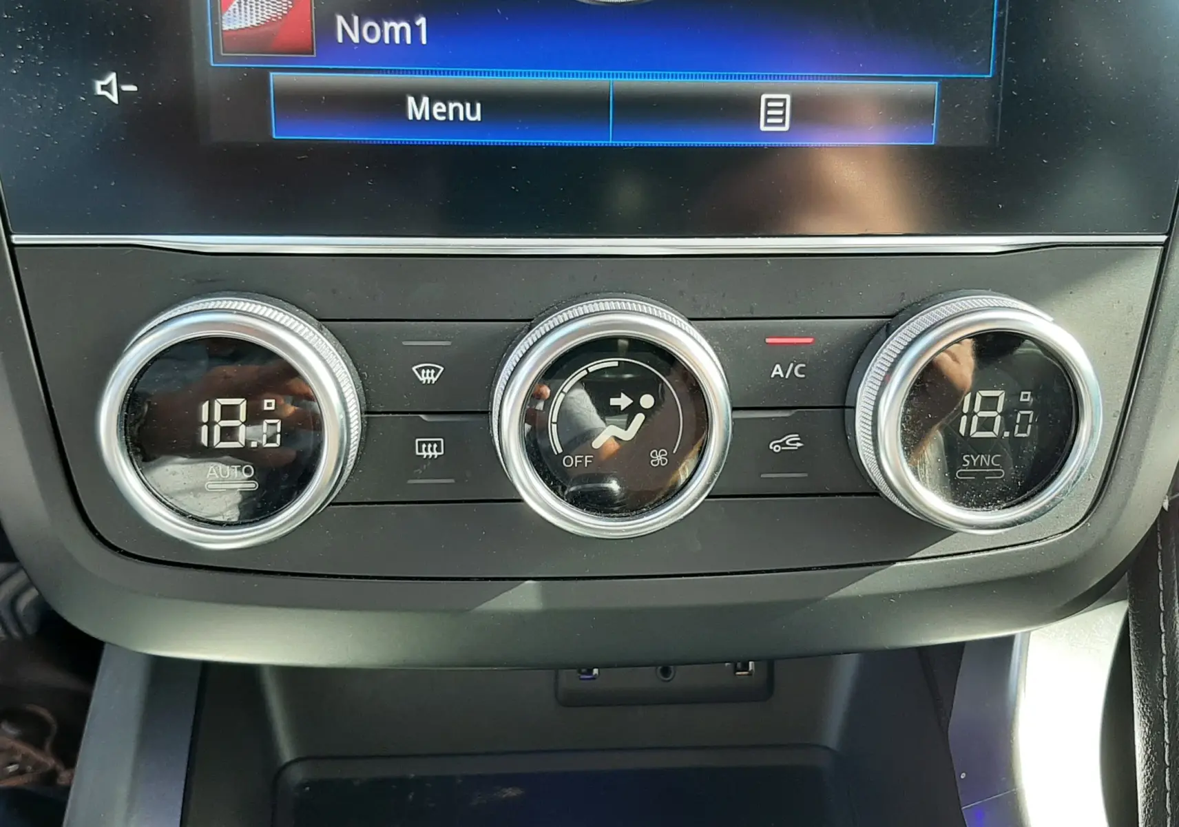 Gros plan sur la console centrale du Renault Kadjar 2021, montrant les commandes de climatisation digitales à 18°C.
