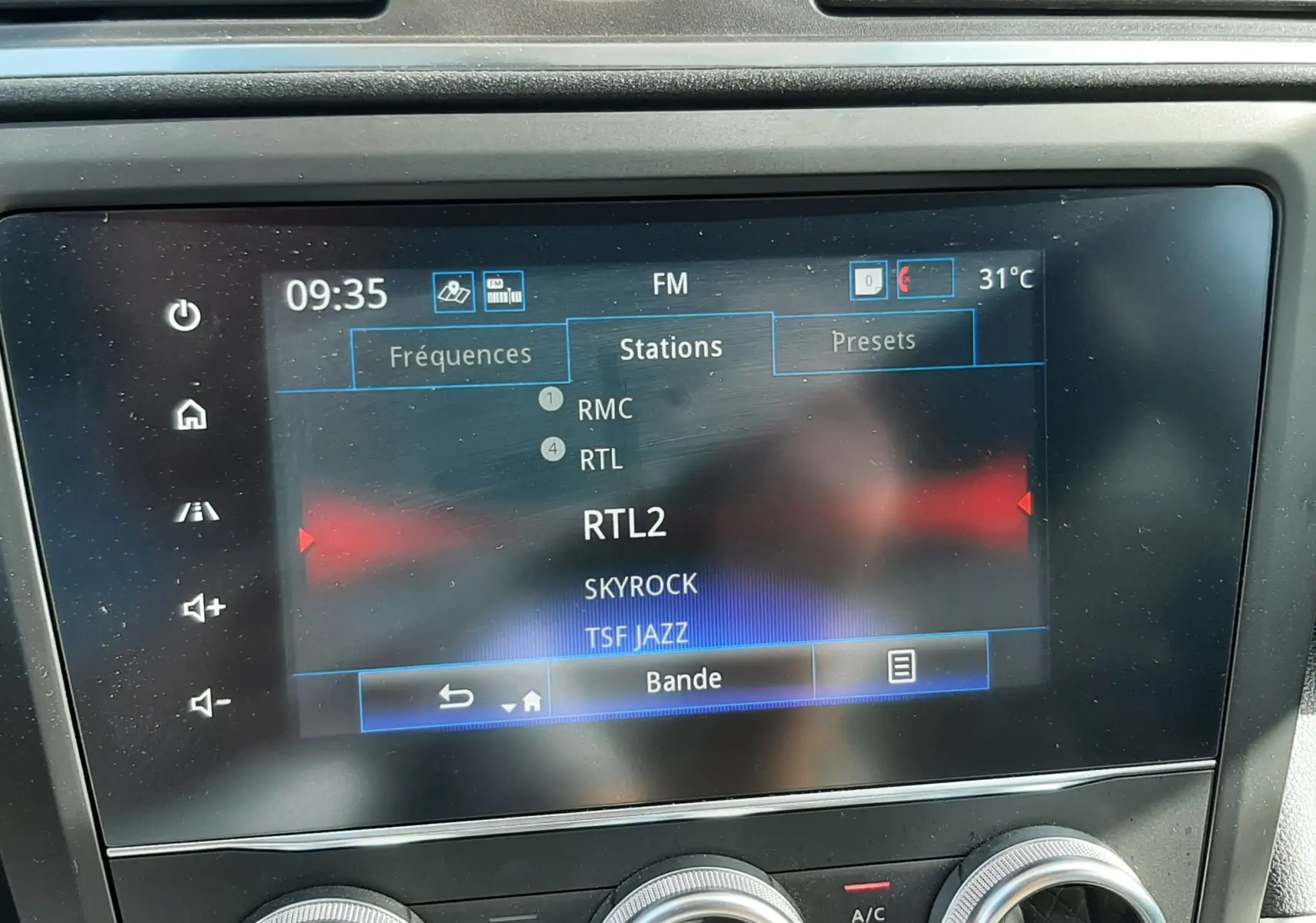 Vue rapprochée de l’écran multimédia et des commandes de climatisation du Renault Kadjar gris titanium.