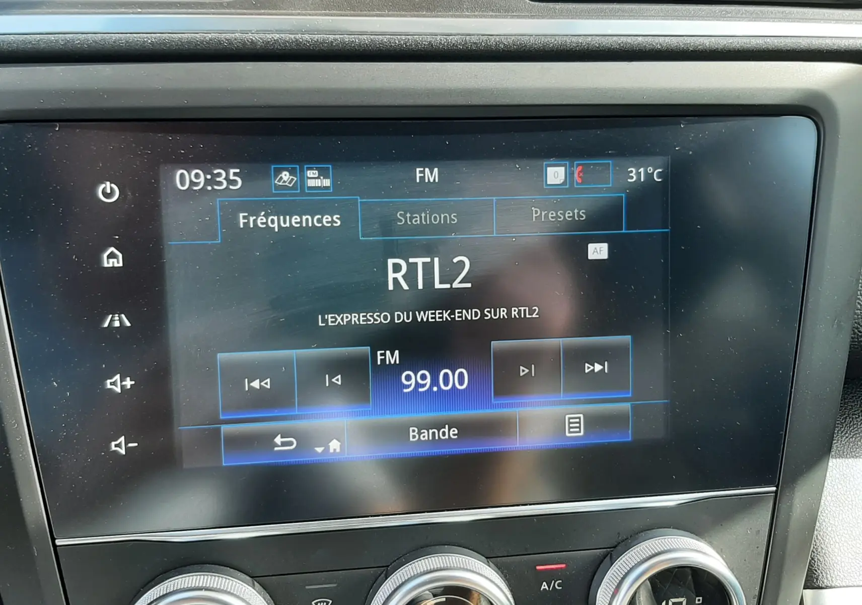 Vue rapprochée de l’écran multimédia et des commandes de climatisation du Renault Kadjar gris titanium, intérieur noir.