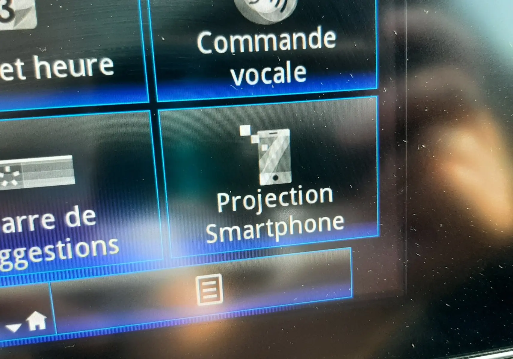 Gros plan sur l'écran tactile du Renault Kadjar gris titanium 2021 montrant les options de commande vocale et projection smartphone.