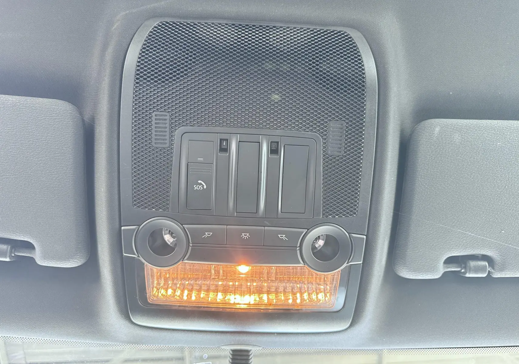 Plafonnier intérieur avec éclairage orange et commandes, vue du toit d'une BMW X6 noire de 2011.