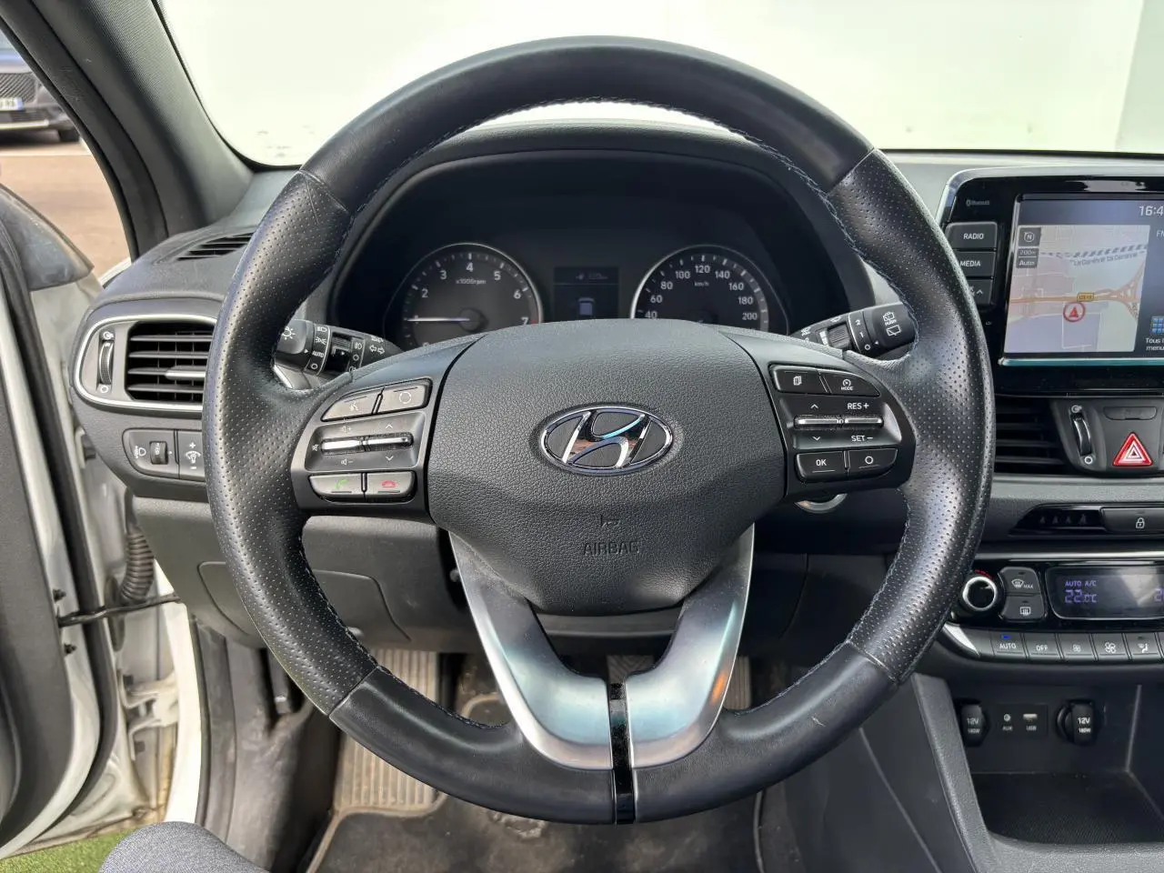 Volant cuir noir avec commandes intégrées et tableau de bord de la Hyundai i30 III SW blanc vue côté conducteur intérieur