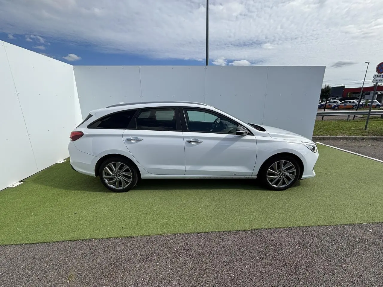 Profil droit d'une Hyundai i30 SW blanche 2018 sur fond clair, avec jantes alliage 17 pouces et vitres surteintées.