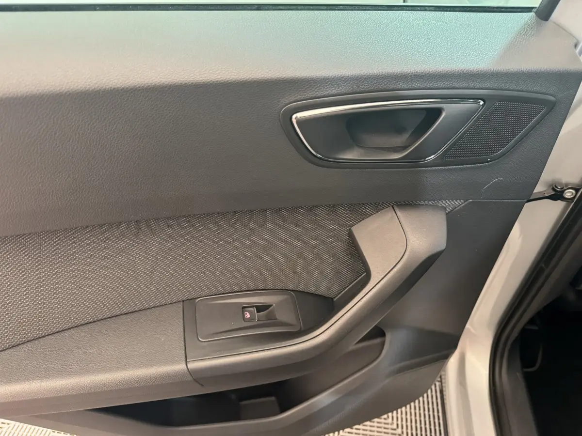 Intérieur de la porte côté conducteur du SEAT Ateca gris clair, avec poignée et commande de vitre électrique.