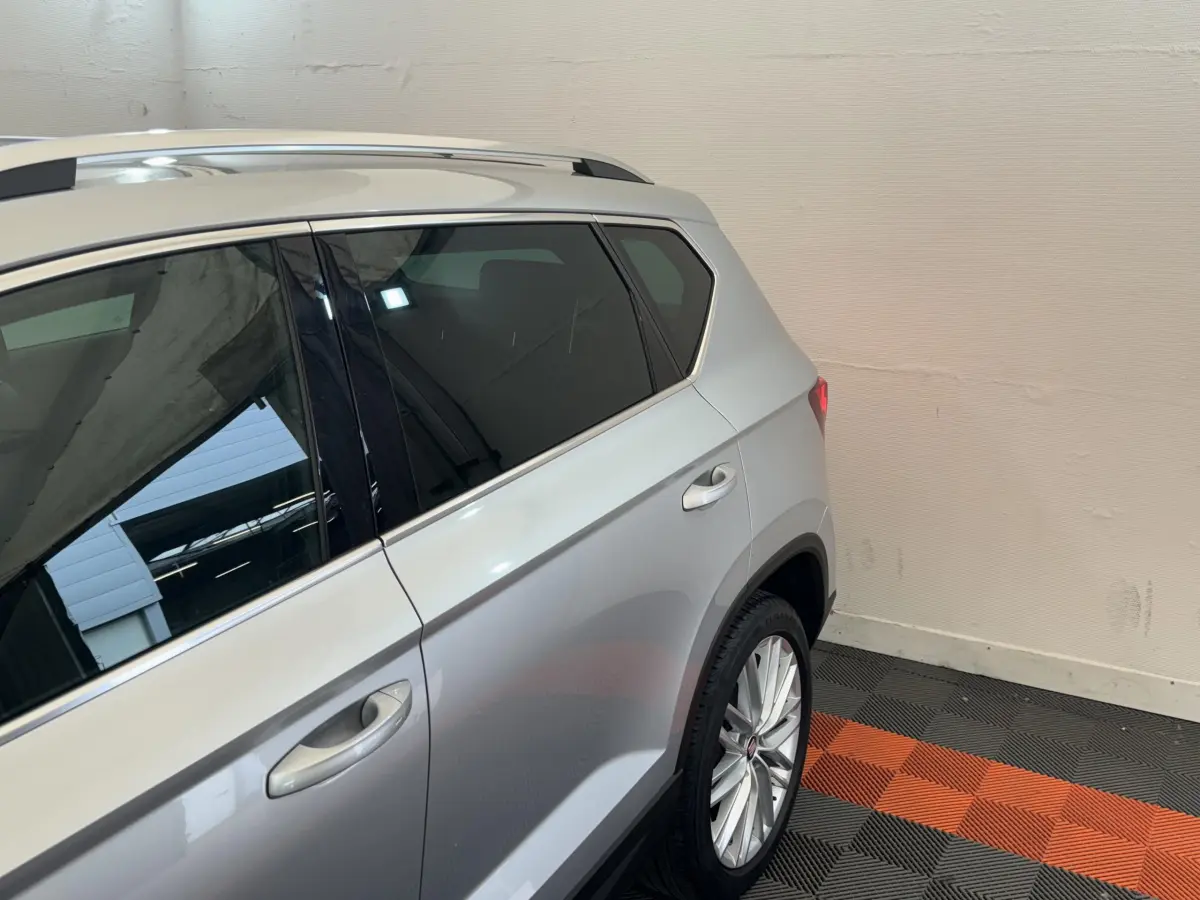 Vue côté droit arrière du SEAT Ateca gris clair, soulignant la porte arrière et la jante alliage multi-branches.