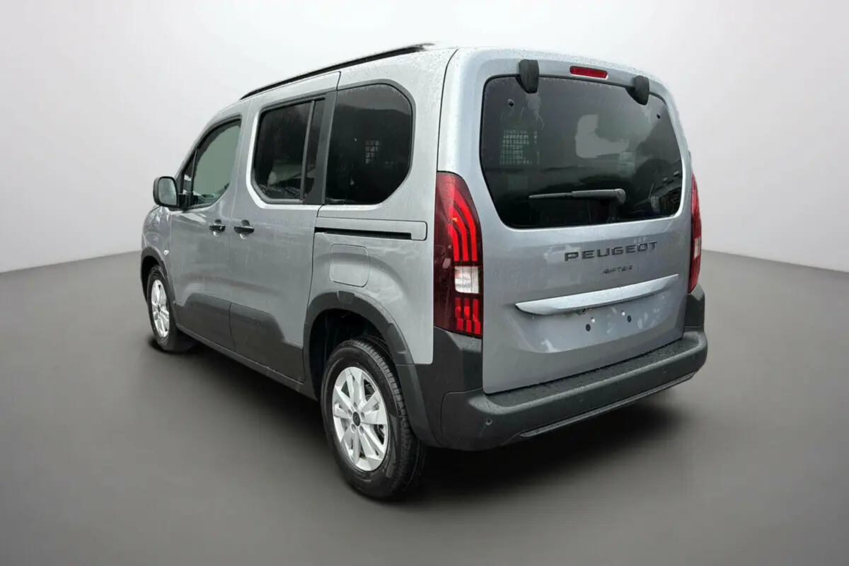 Peugeot Rifter BlueHDi 130 Allure gris Artense vu 3/4 arrière droit avec vitres surteintées et grille de séparation dans le coffre.
