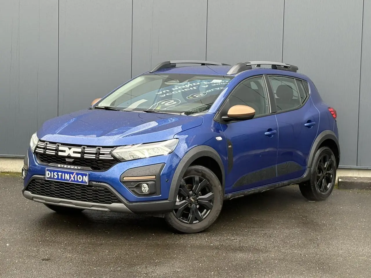 Dacia Sandero Stepway Bleu Iron vue 3/4 avant droit avec jantes noires et coques de rétroviseur cuivrées