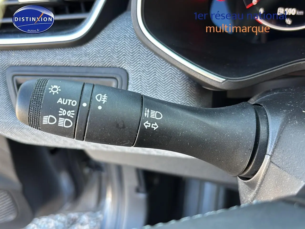 Gros plan sur la commande des feux et clignotants côté gauche du tableau de bord d'une Renault Clio V gris pizarra.