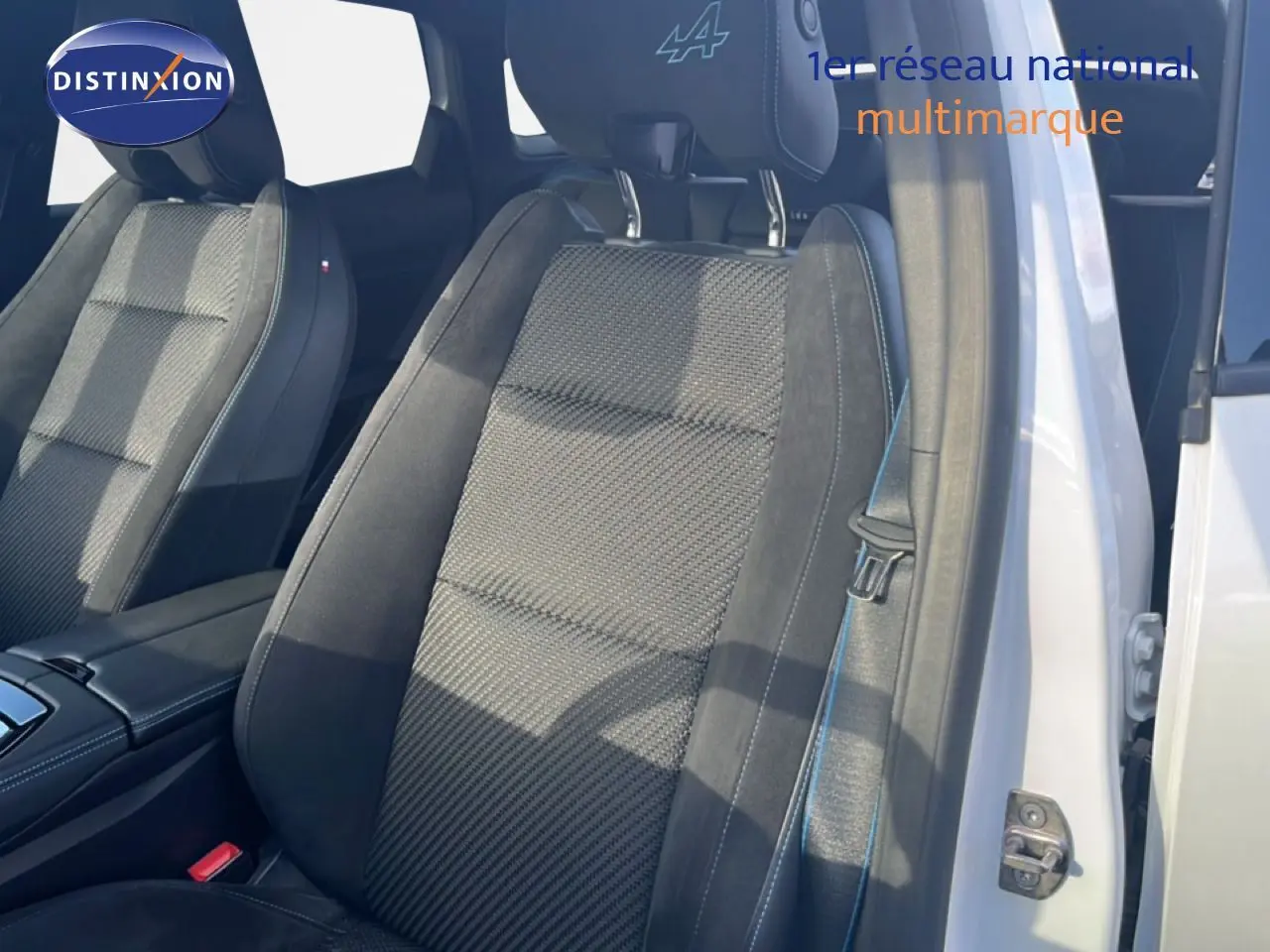 Gros plan sur le siège avant droit noir et gris avec surpiqûres bleues et logo Alpine sur l'appuie-tête du Renault Austral Iconic Esprit Alpine.