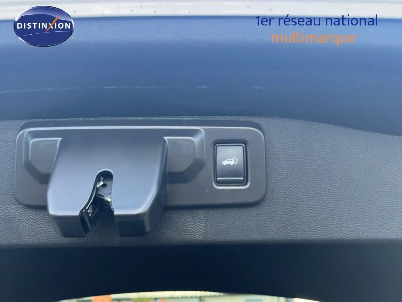 Gros plan sur la commande d'ouverture du coffre dans un Renault Austral Iconic Esprit Alpine blanc/noir 2024.