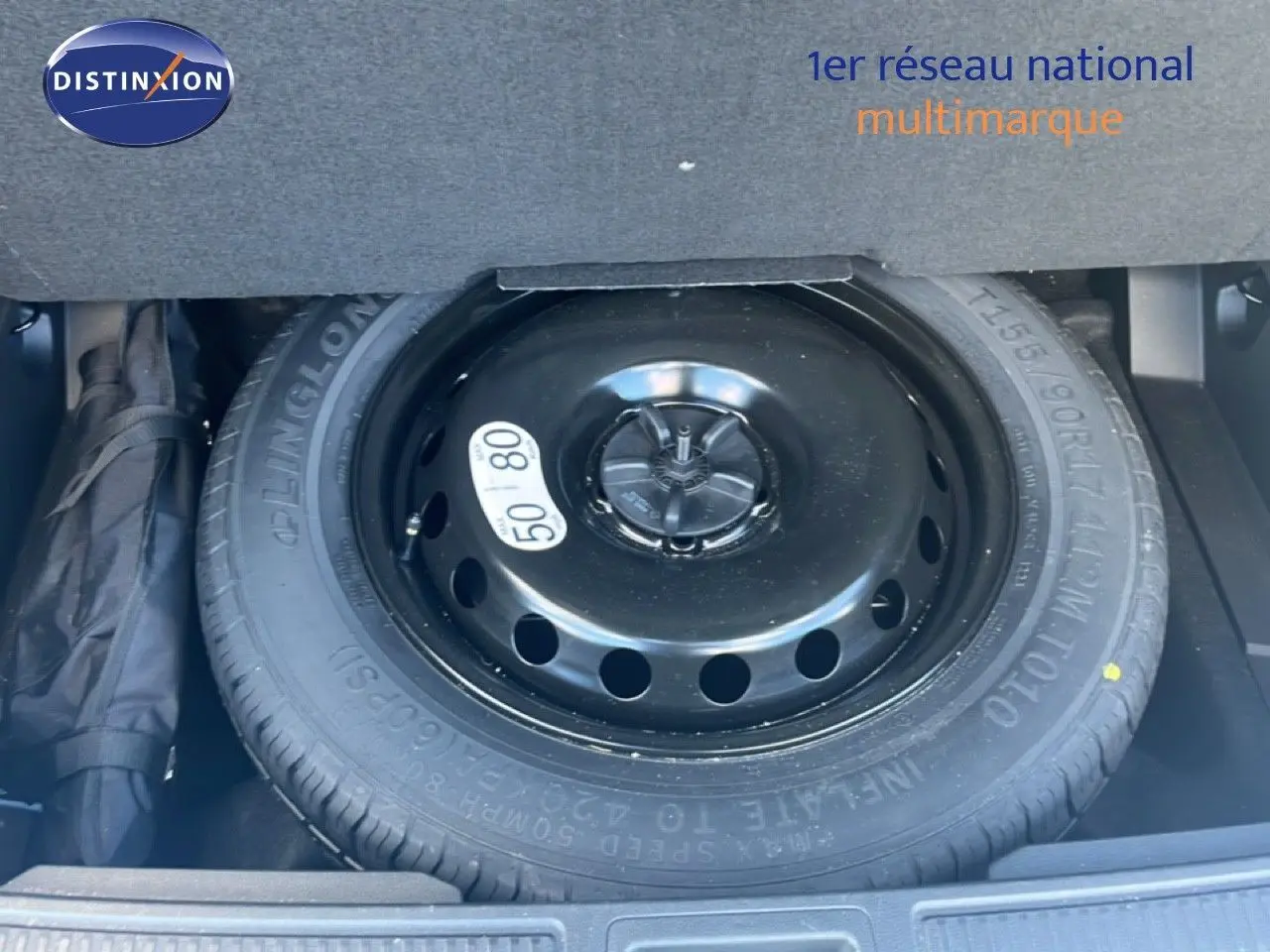 Roue de secours noire en gros plan dans le coffre d'un Renault Austral Iconic Esprit Alpine blanc/noir 2024.