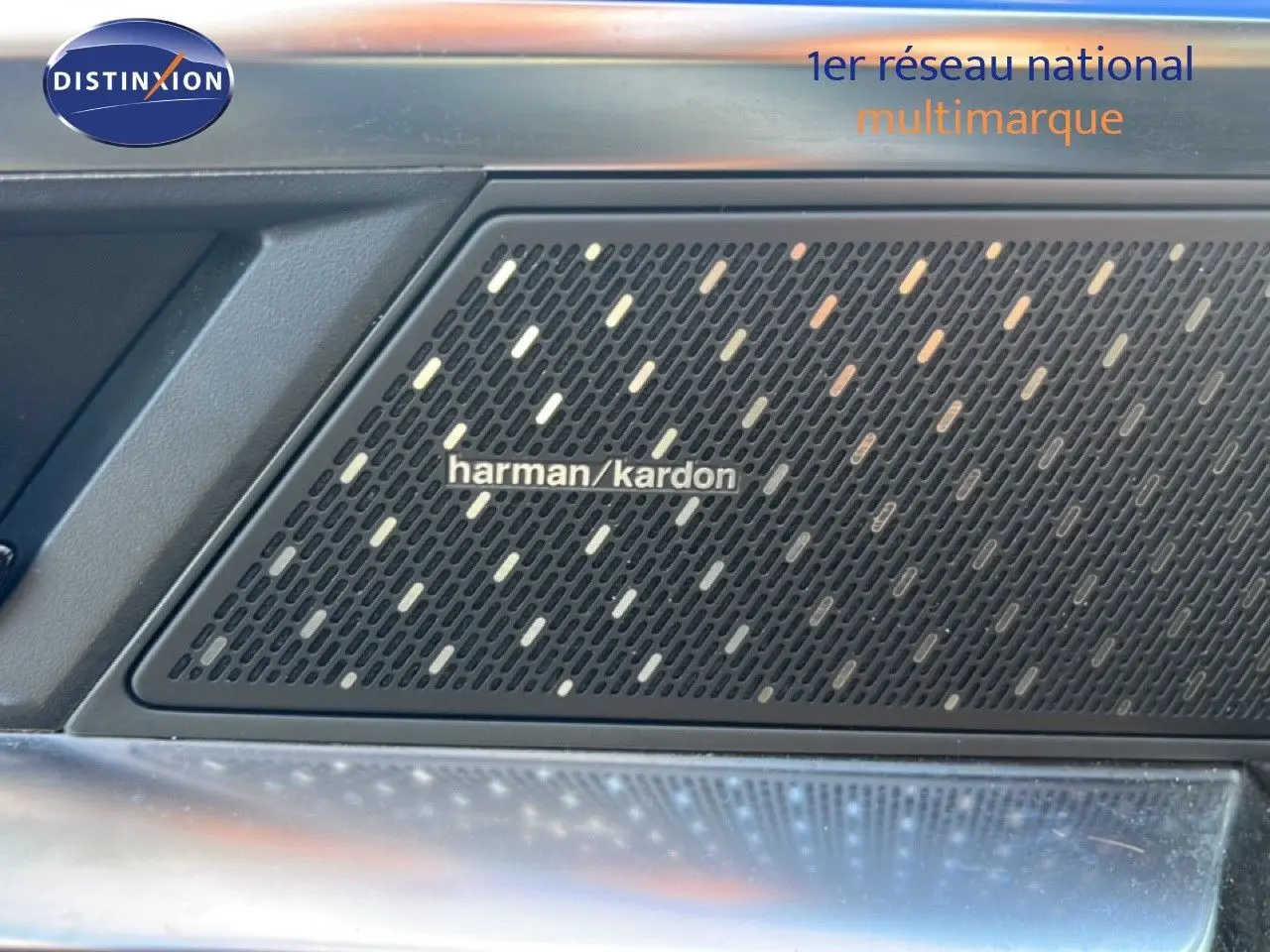 Gros plan sur l'enceinte Harman Kardon intégrée à la porte intérieure du Renault Austral Iconic Esprit Alpine blanc et noir.