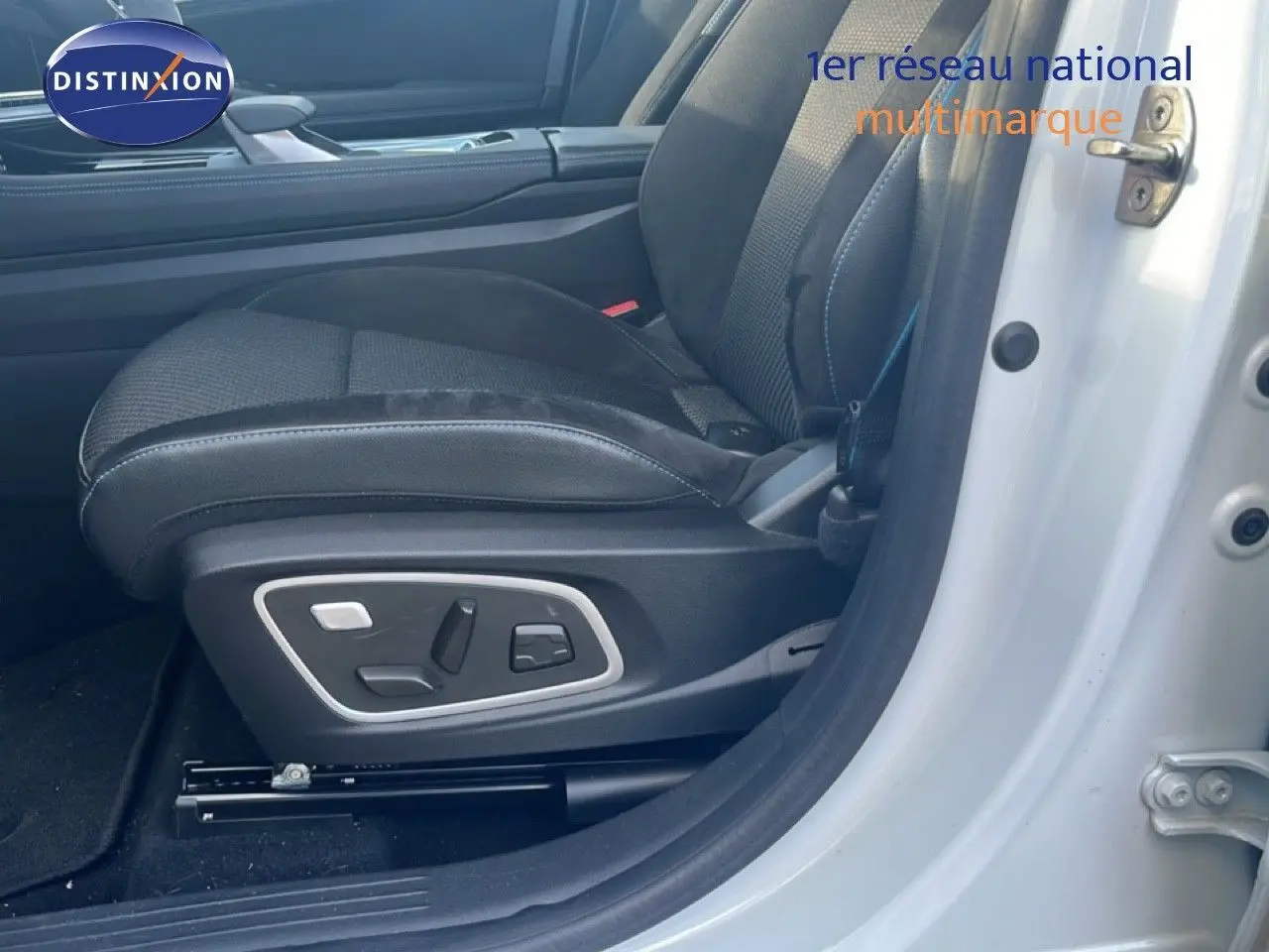 Gros plan sur le siège conducteur noir avec réglages électriques, porte ouverte d'une Renault Austral Iconic Esprit Alpine blanc/noir 2024.