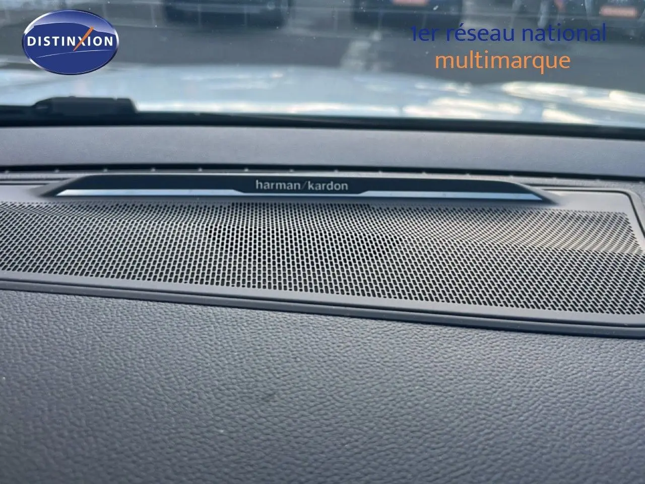 Gros plan sur la grille de haut-parleur Harman Kardon intégrée au tableau de bord du Renault Austral Iconic Esprit Alpine blanc et noir.