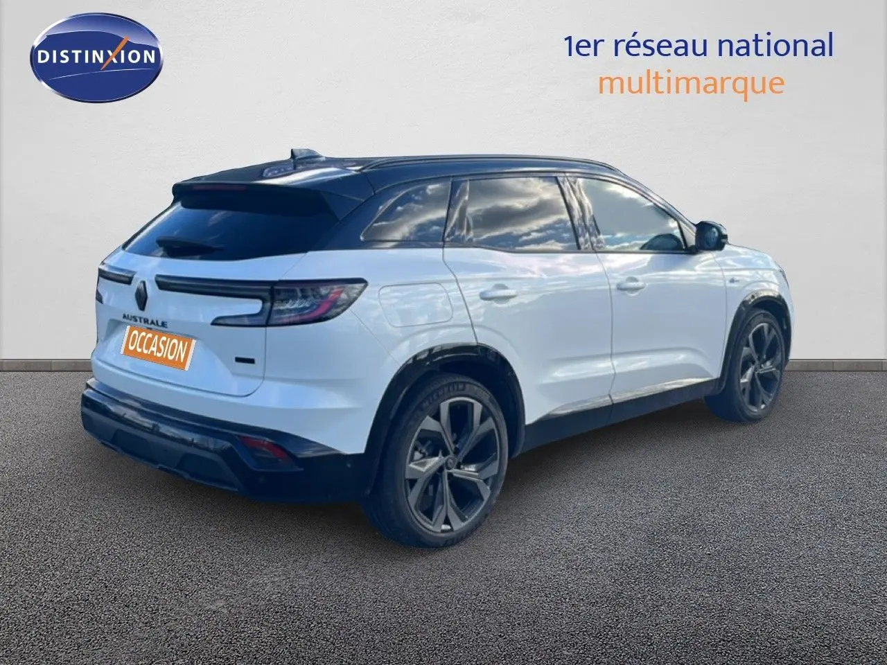 Vue 3/4 arrière droite du Renault Austral Iconic Esprit Alpine blanc et noir avec jantes foncées sur sol gris.