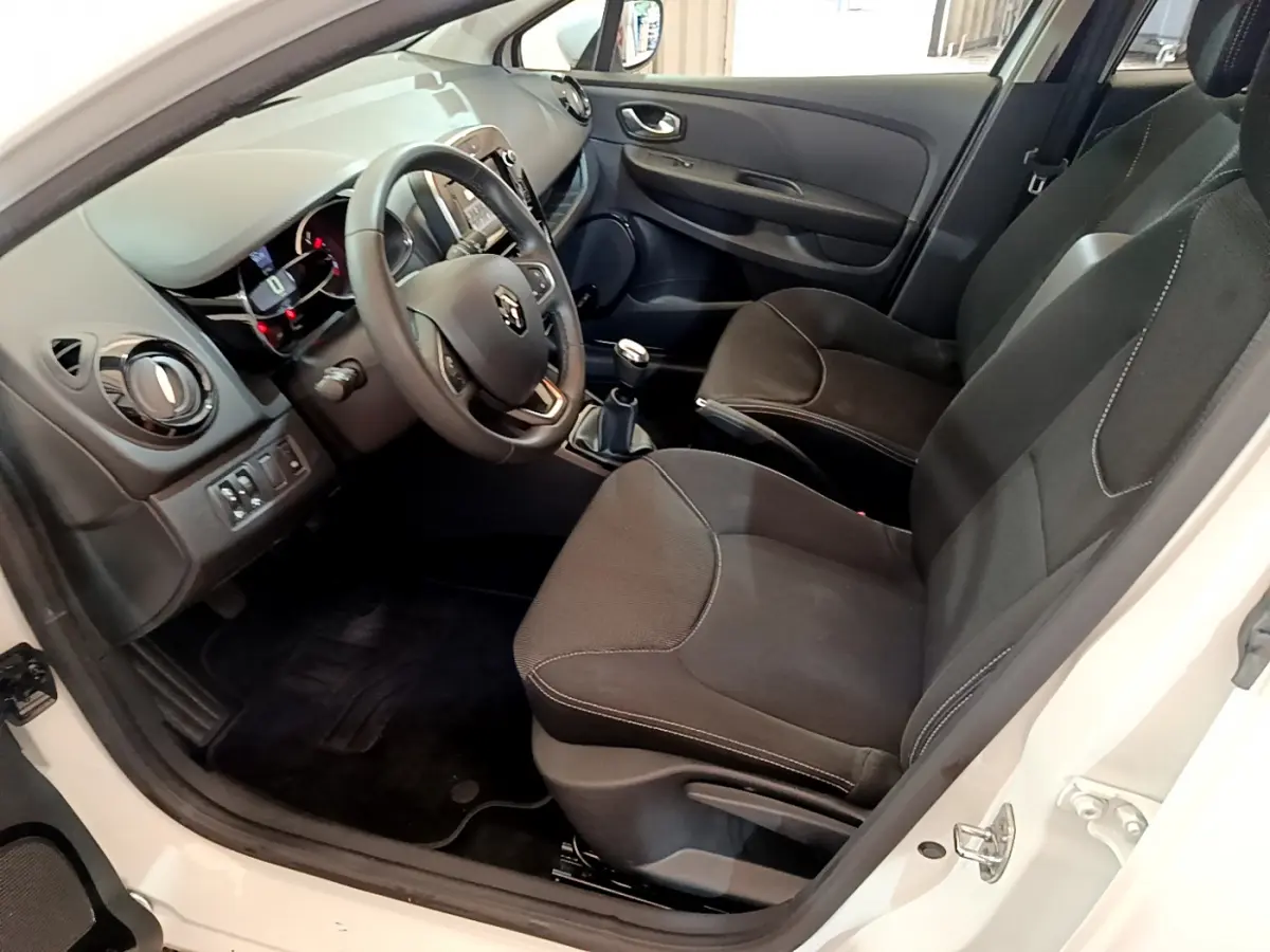 Intérieur avant droit d'une Renault Clio Business TCe 90 blanche, volant cuir, tableau de bord avec écran tactile.