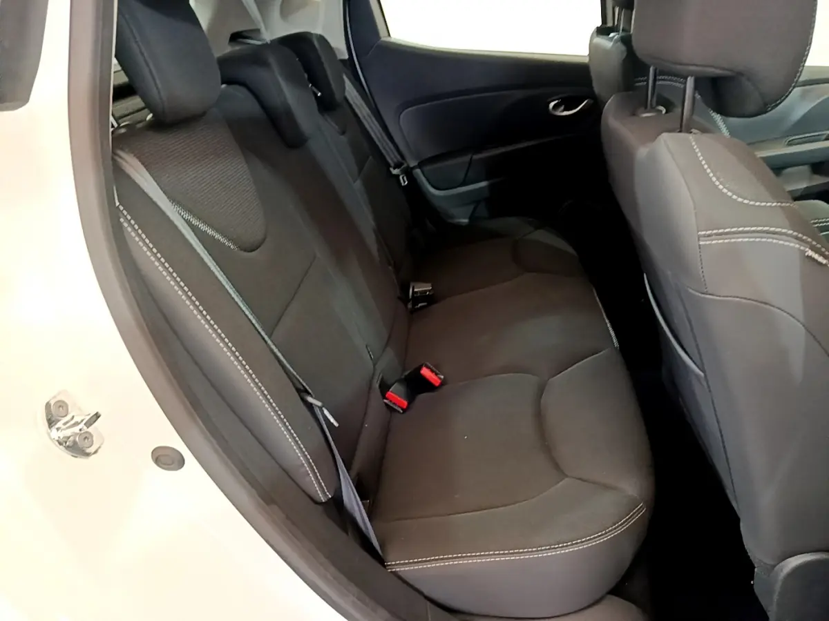 Vue intérieure côté gauche montrant la banquette arrière noire avec surpiqûres blanches d'une Renault Clio Business blanche.