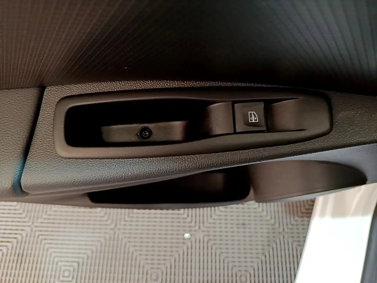 Gros plan sur la commande de lève-vitre côté conducteur de la Renault Clio Business TCe 90 blanche de 2019.