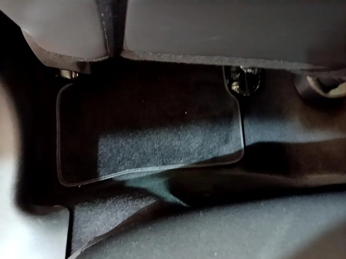 Gros plan sur le tapis de sol noir sous le siège avant d'une Renault Clio Business TCe 90 blanche de 2019.