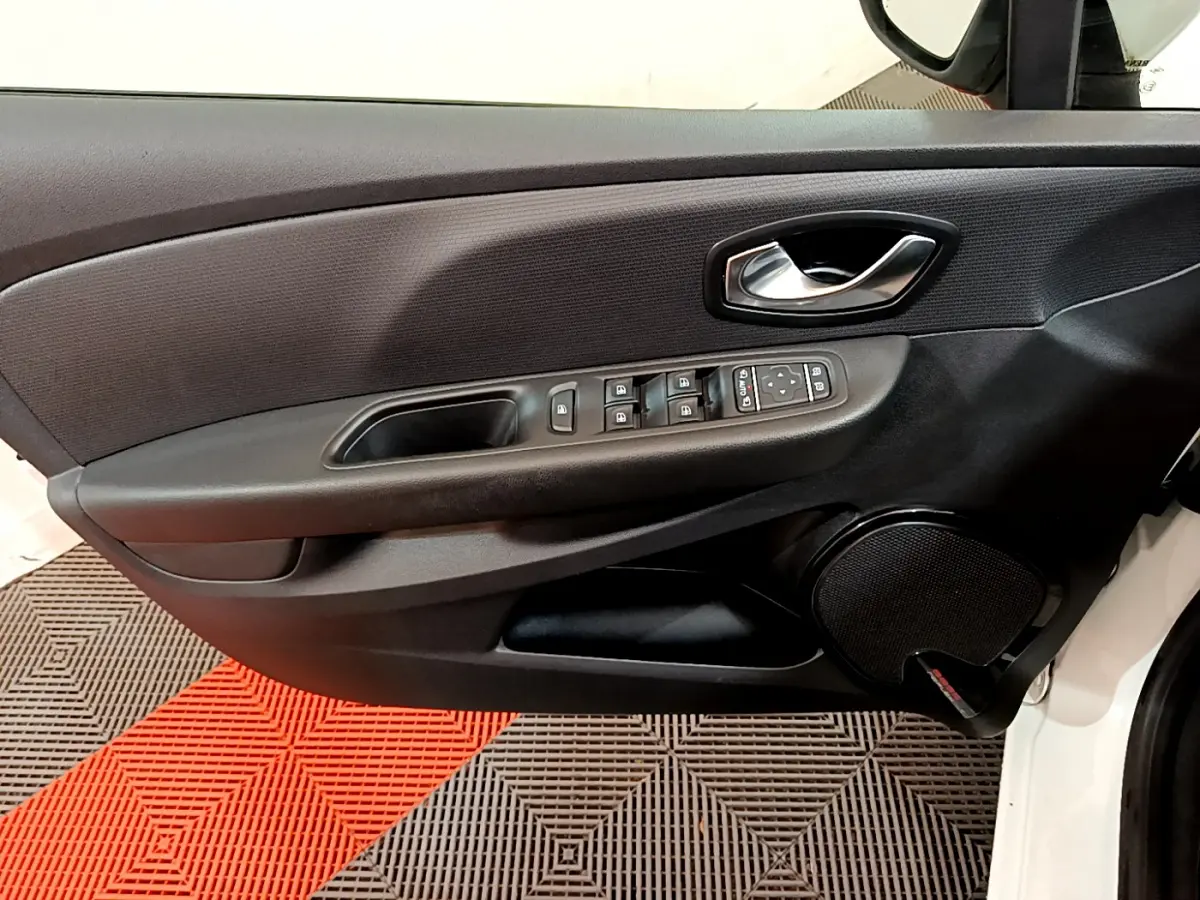 Vue intérieure du panneau de porte côté conducteur d'une Renault Clio Business TCe 90 blanche avec commandes électriques et haut-parleur intégré.