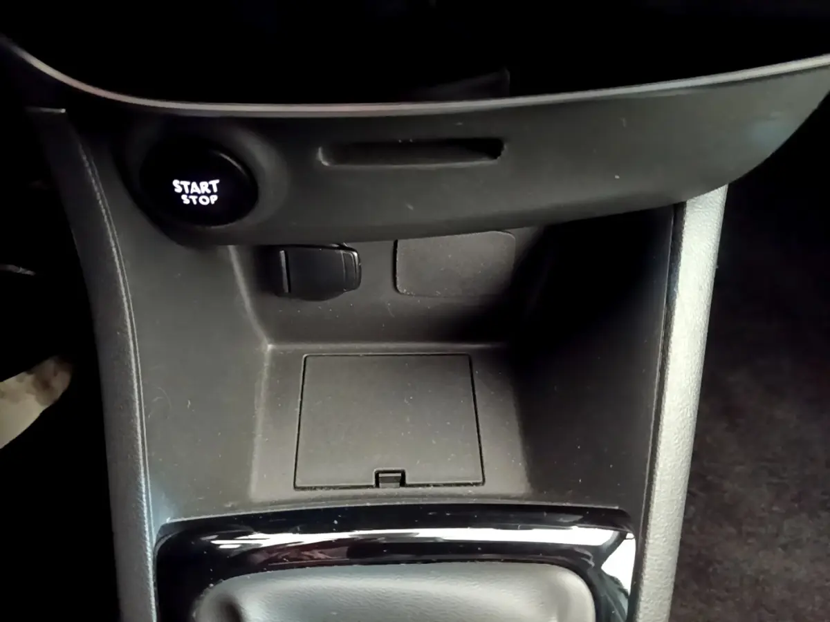 Gros plan sur la console centrale noire de la Renault Clio Business avec bouton Start/Stop éclairé.