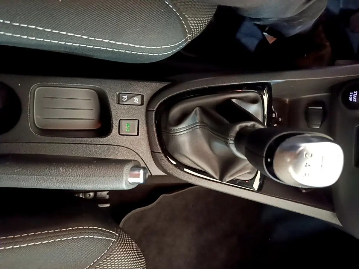 Vue rapprochée de la console centrale noire de la Renault Clio Business TCe 90 avec levier de vitesse manuel et bouton Start/Stop.