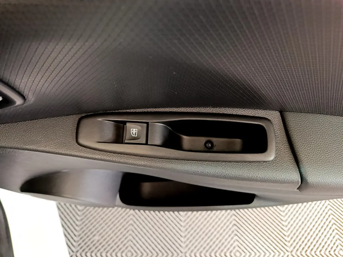 Bouton de commande de lève-vitre sur la portière côté conducteur d'une Renault Clio Business blanche de 2019.