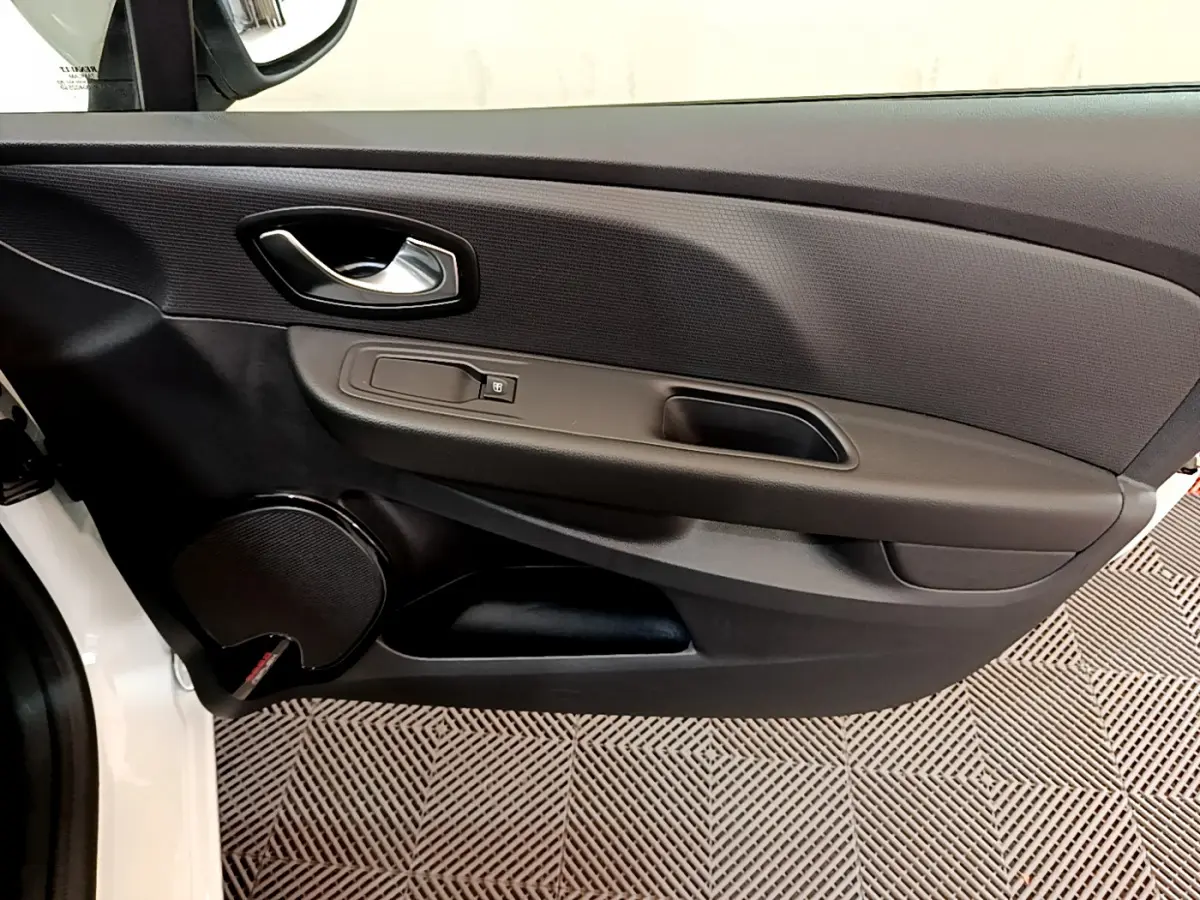 Gros plan sur la porte avant gauche noire de la Renault Clio Business TCe 90 blanche, avec poignée et haut-parleur intégrés.