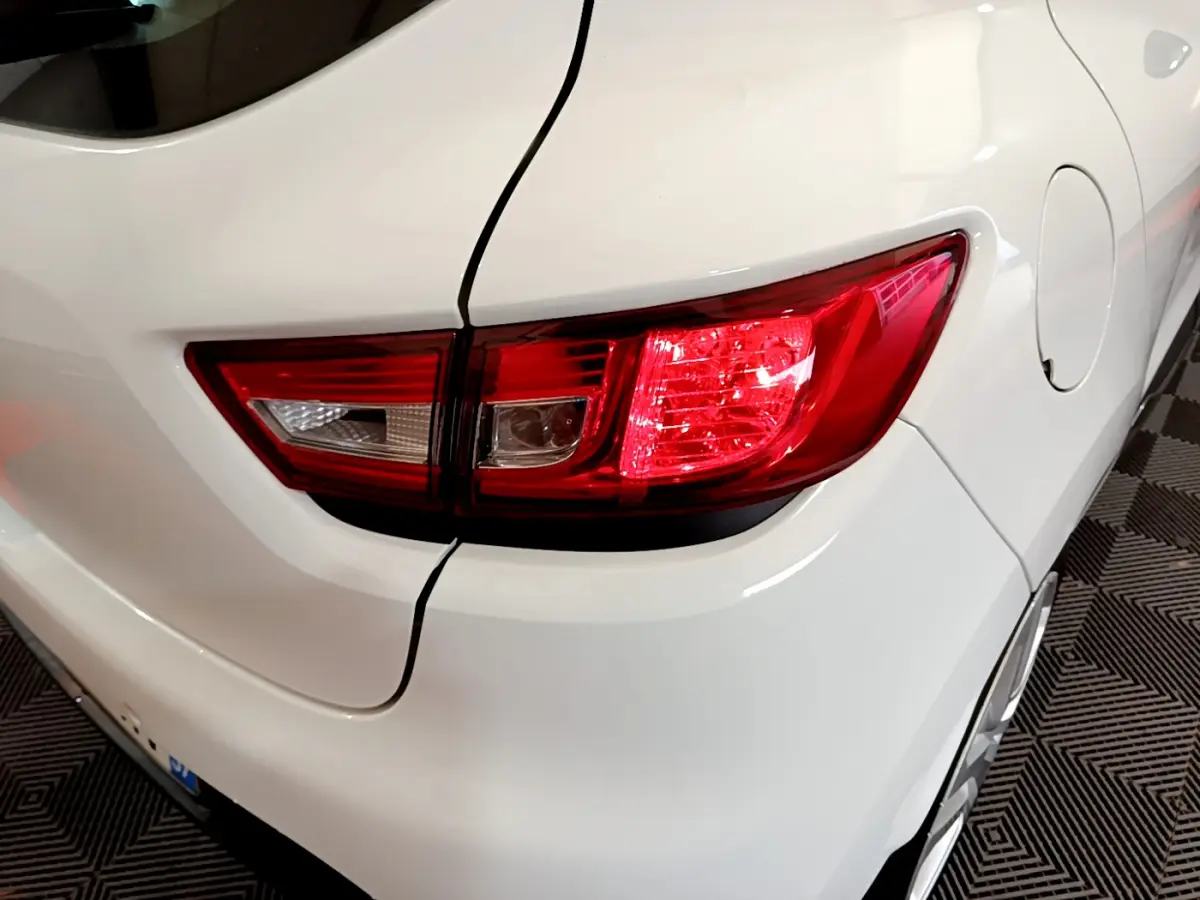 Gros plan sur le feu arrière droit d'une Renault Clio Business TCe 90 blanche, avec la trappe à carburant visible sur le côté.