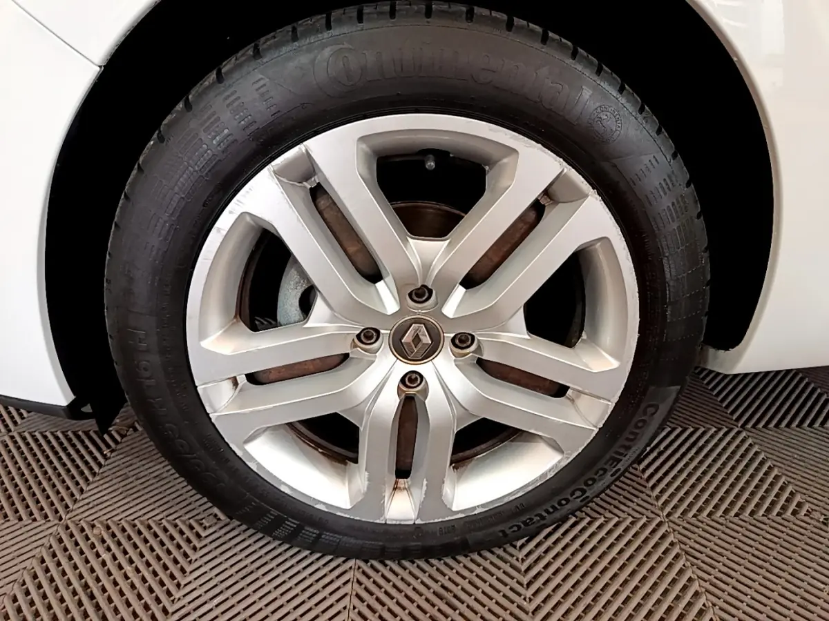 Gros plan sur la roue avant droite d'une Renault Clio Business TCe 90 blanche avec jante alliage à 5 branches doubles.