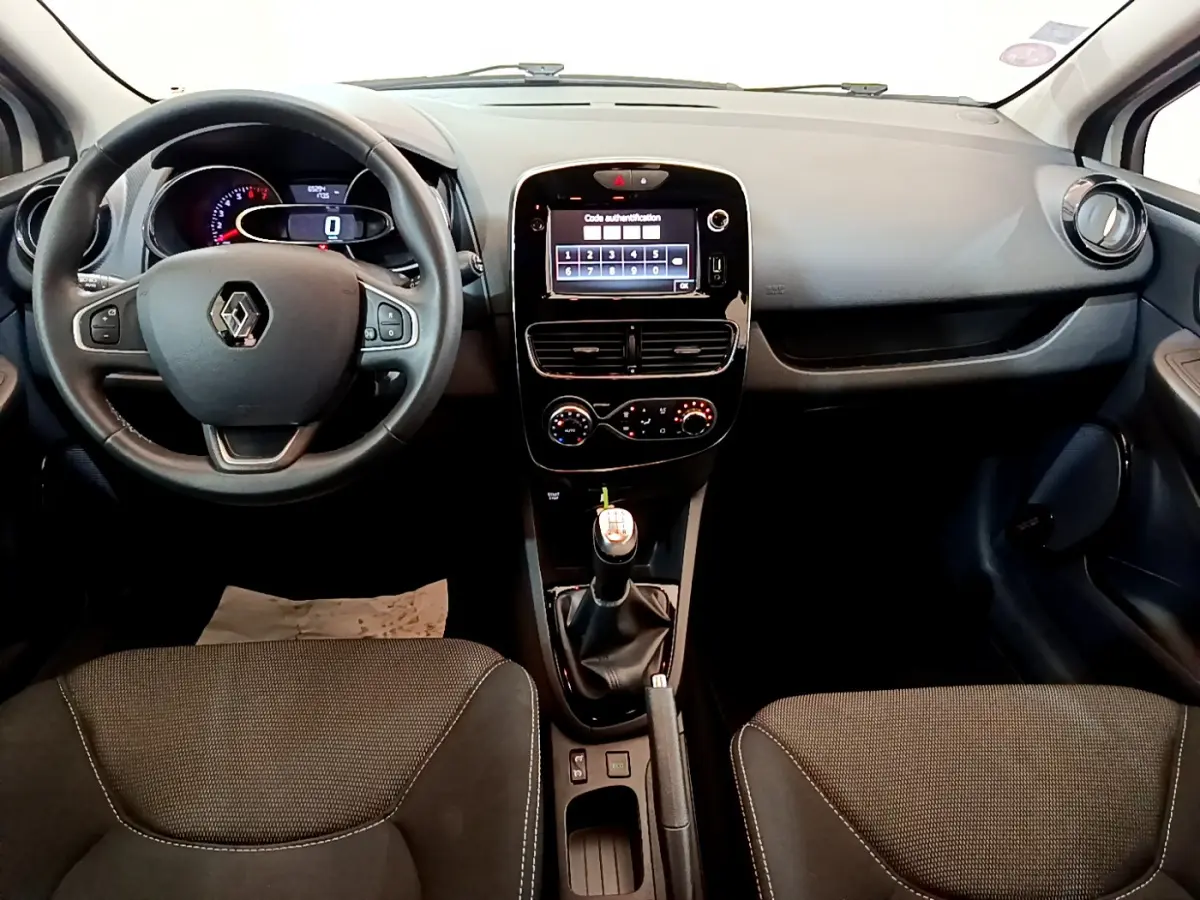 Vue frontale de l'intérieur noir de la Renault Clio Business TCe 90 2019, avec volant cuir et écran tactile central allumé.