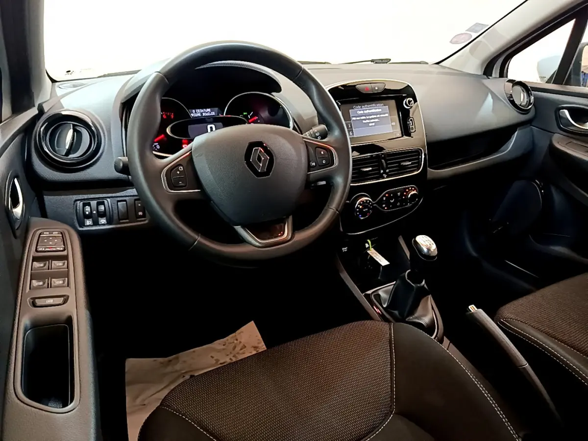 Intérieur avant de la Renault Clio Business TCe 90 2019, tableau de bord noir avec écran tactile et volant cuir multifonctions.