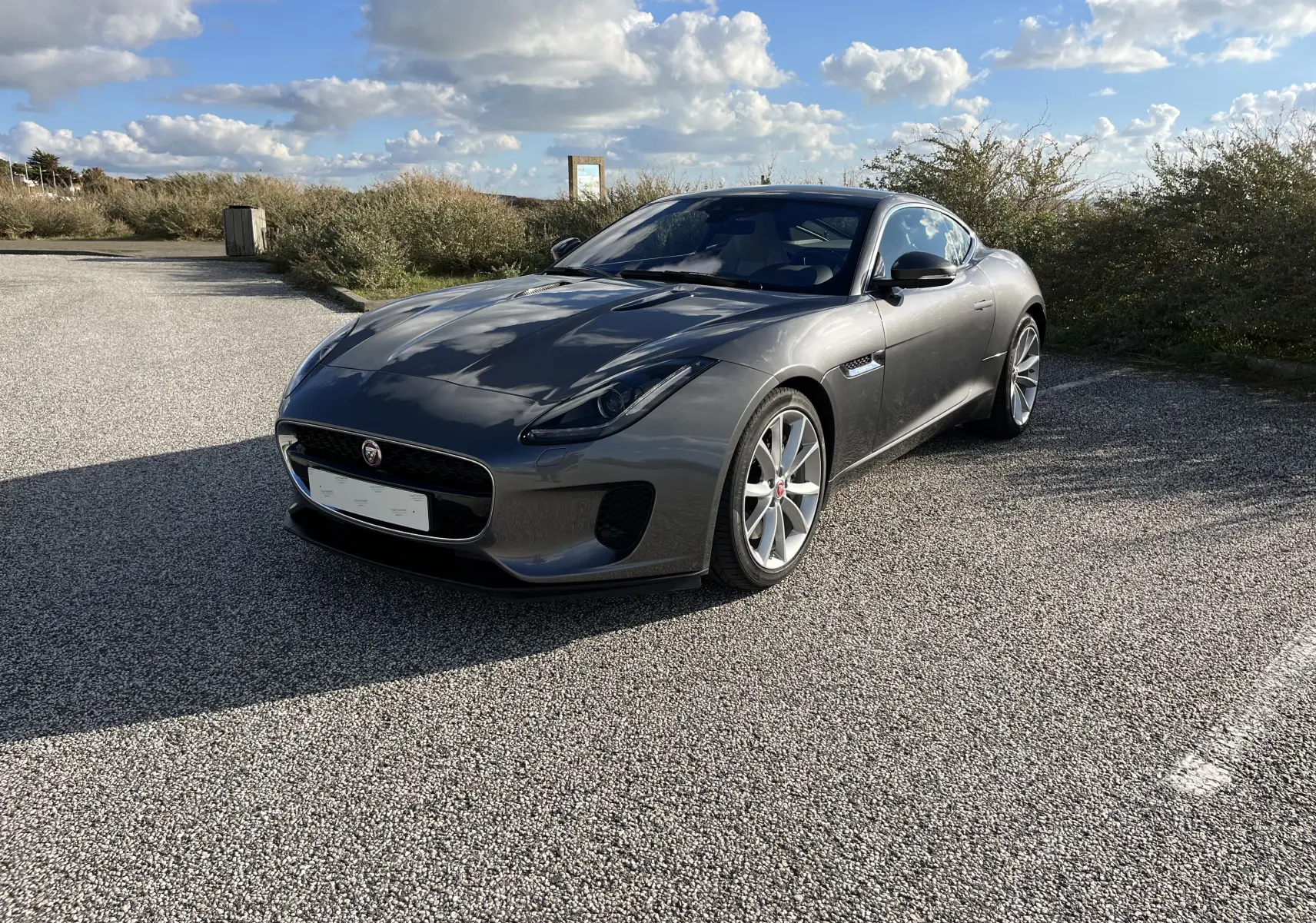Jaguar F-TYPE II Coupé 2.0T gris Corris en 3/4 avant droit, jantes 19 pouces et calandre distinctive.