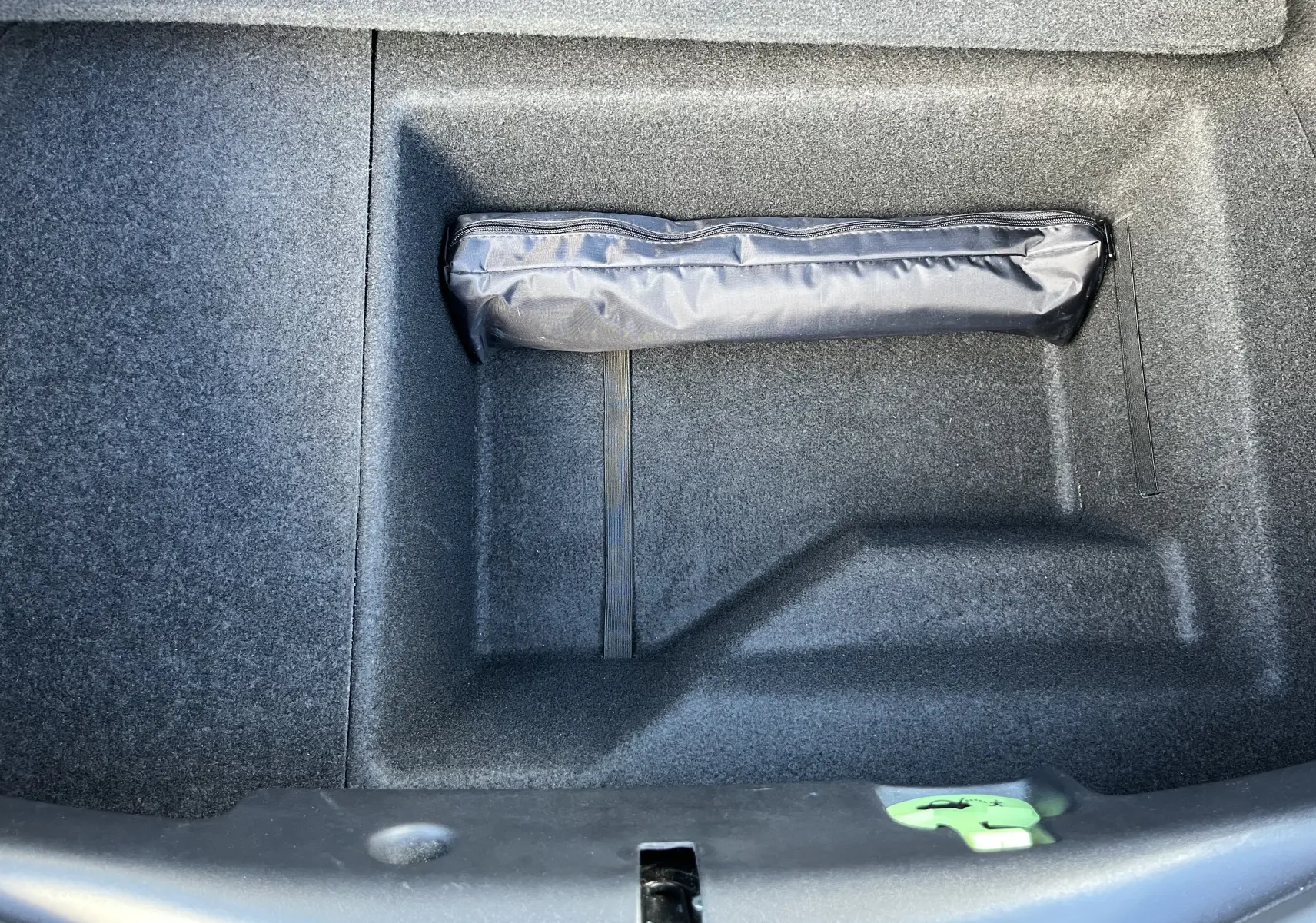 Coffre ouvert de la Jaguar F-TYPE II Coupe 2.0T 2018 en Corris Grey, montrant un rangement avec une trousse noire.