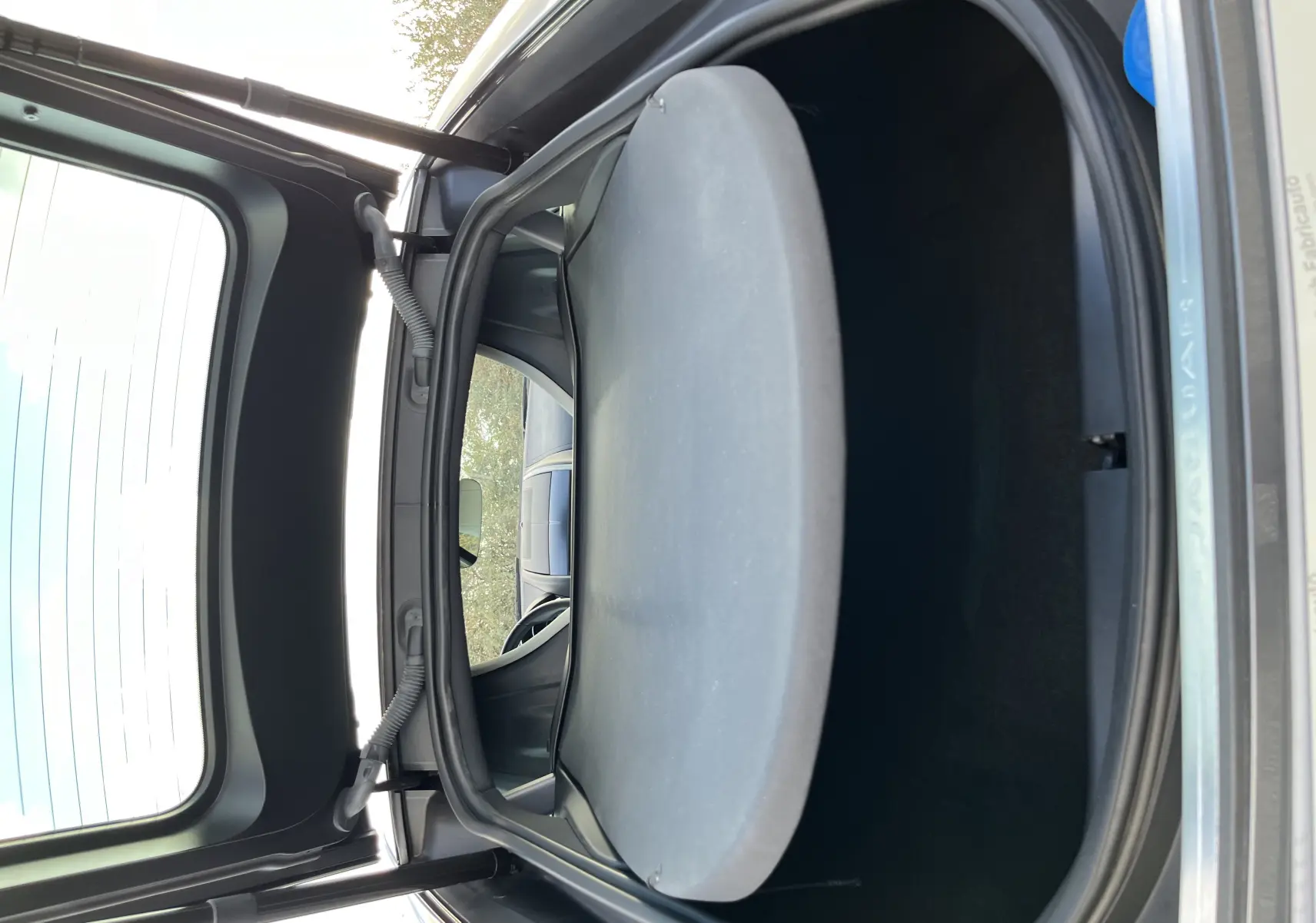 Coffre ouvert vu de l'arrière d'une Jaguar F-TYPE II Coupé 2.0T 300 BVA8 gris Corris, montrant l'espace de rangement.
