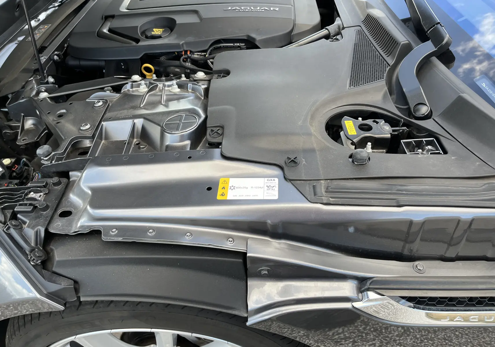 Vue rapprochée du compartiment moteur de la Jaguar F-TYPE II Coupé 2.0T 2018 en gris Corris, avec détails du capot ouvert.