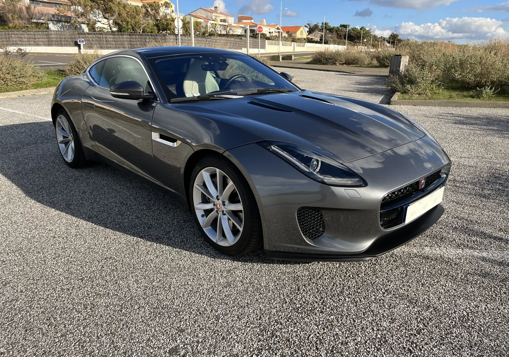 Jaguar F-TYPE II Coupé 2.0T 2018 gris Corris, vue 3/4 avant droit avec jantes 19 pouces et phares LED.