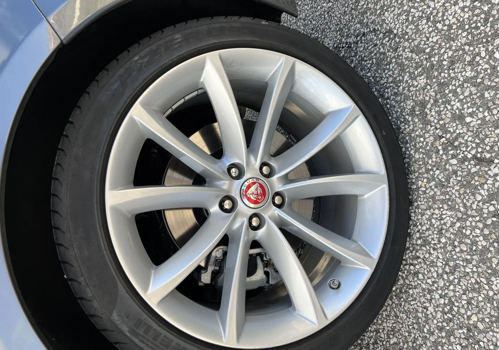 Gros plan sur la jante 19 pouces argentée à 10 branches de la Jaguar F-TYPE II Coupe Corris Grey, avec logo central rouge.