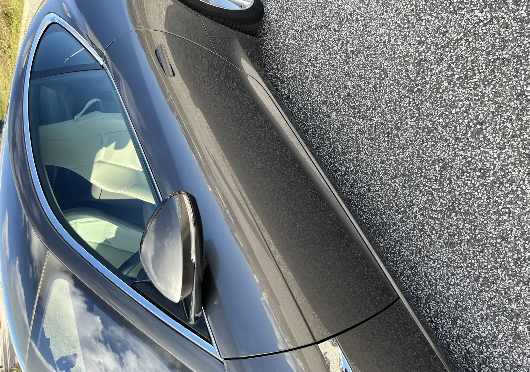 Vue latérale côté gauche d'une Jaguar F-TYPE II Coupé 2.0T 300 BVA8 gris Corris avec jantes 19 pouces et intérieur clair visible.