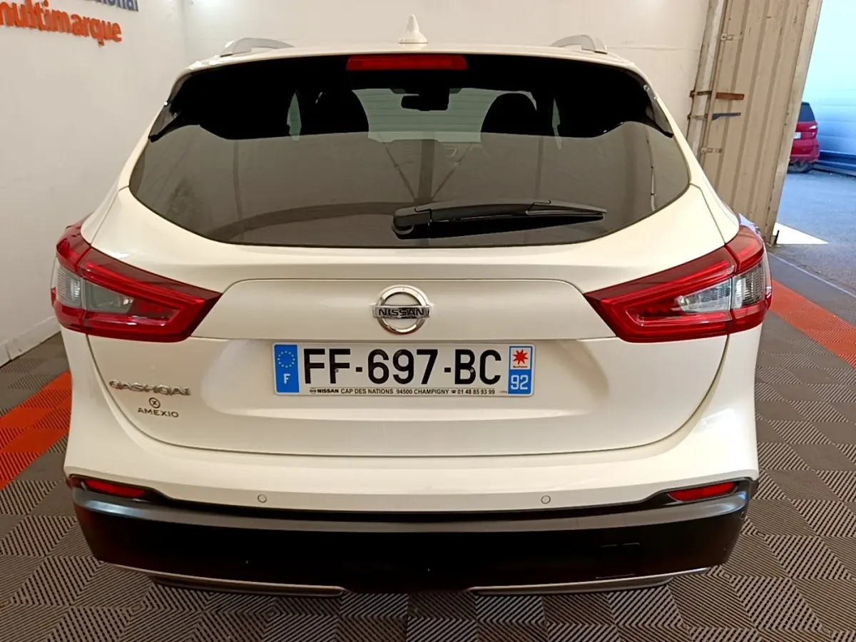 Vue arrière d'un Nissan Qashqai blanc 2019 avec feux arrière LED et plaque d'immatriculation française visible.