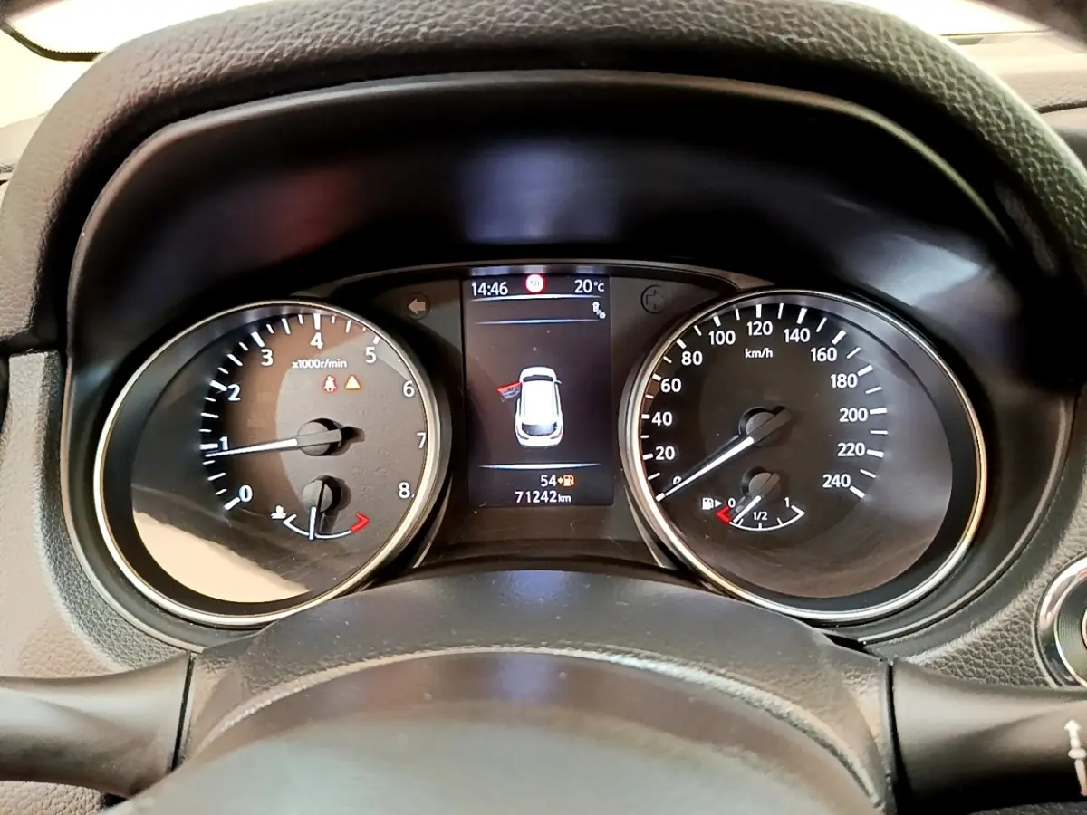 Vue rapprochée du tableau de bord du Nissan Qashqai blanc, affichant compte-tours, vitesse et écran central numérique.