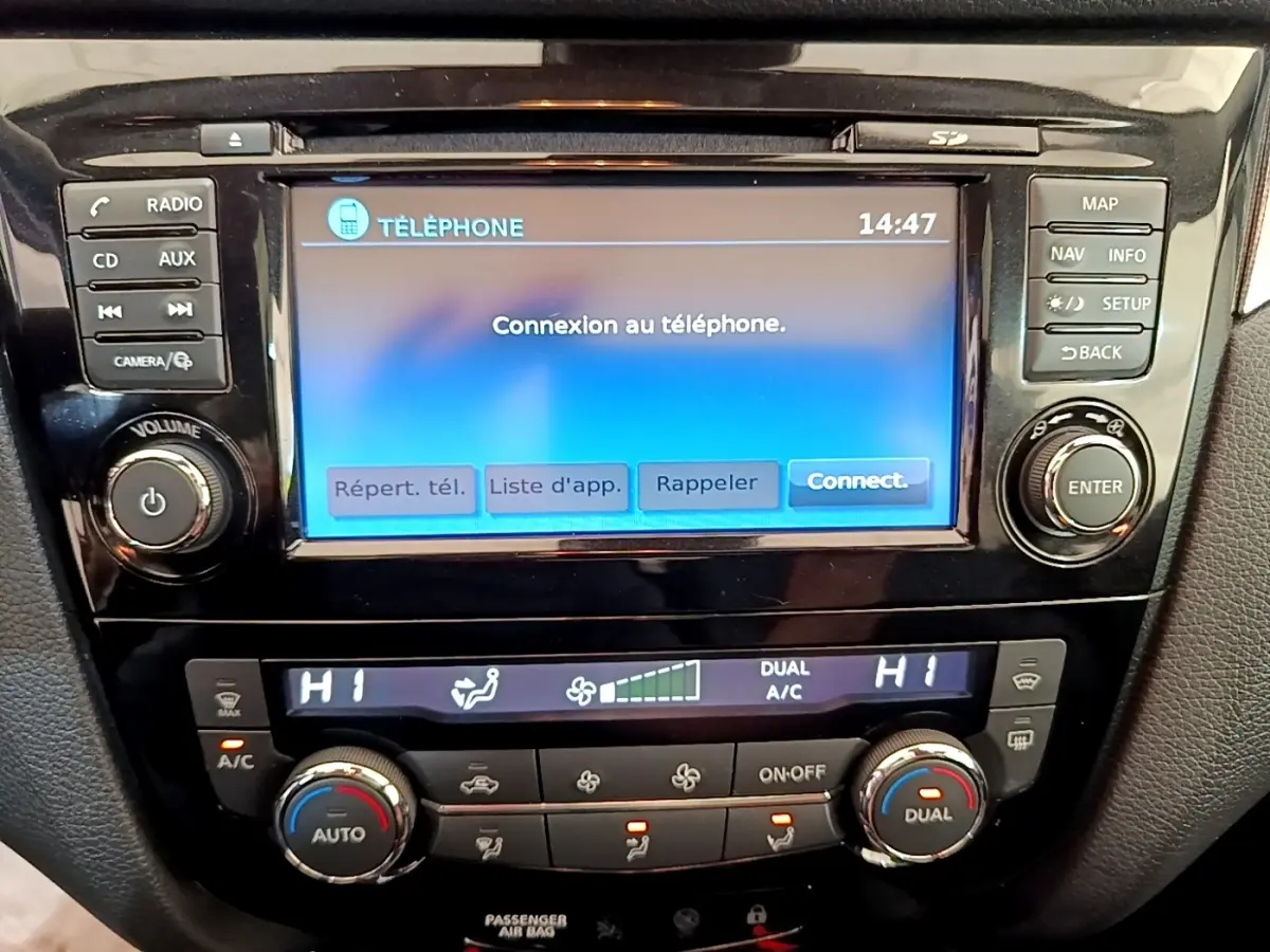 Gros plan sur l’écran tactile central et la console de climatisation du Nissan Qashqai blanc 2019.