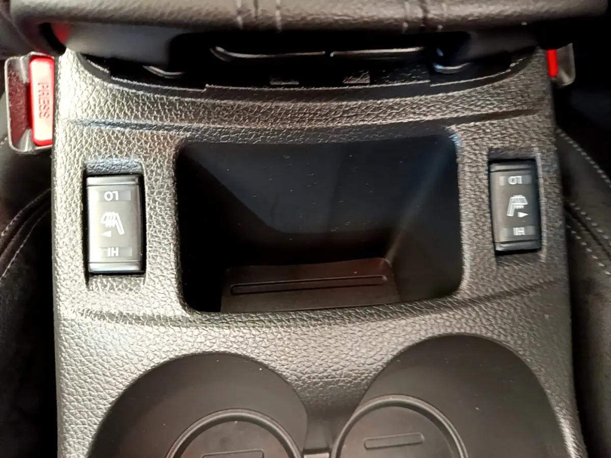 Gros plan sur la console centrale noire du Nissan Qashqai 1.3 DIG-T 140 Tekna avec commandes des sièges chauffants.