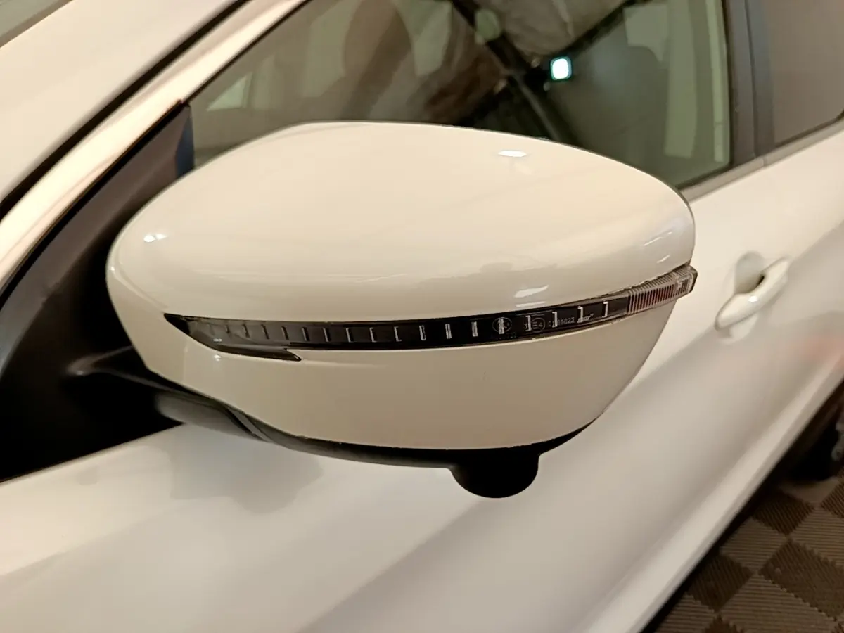Rétroviseur droit blanc du Nissan Qashqai 2019 avec clignotant intégré, vue rapprochée en intérieur.